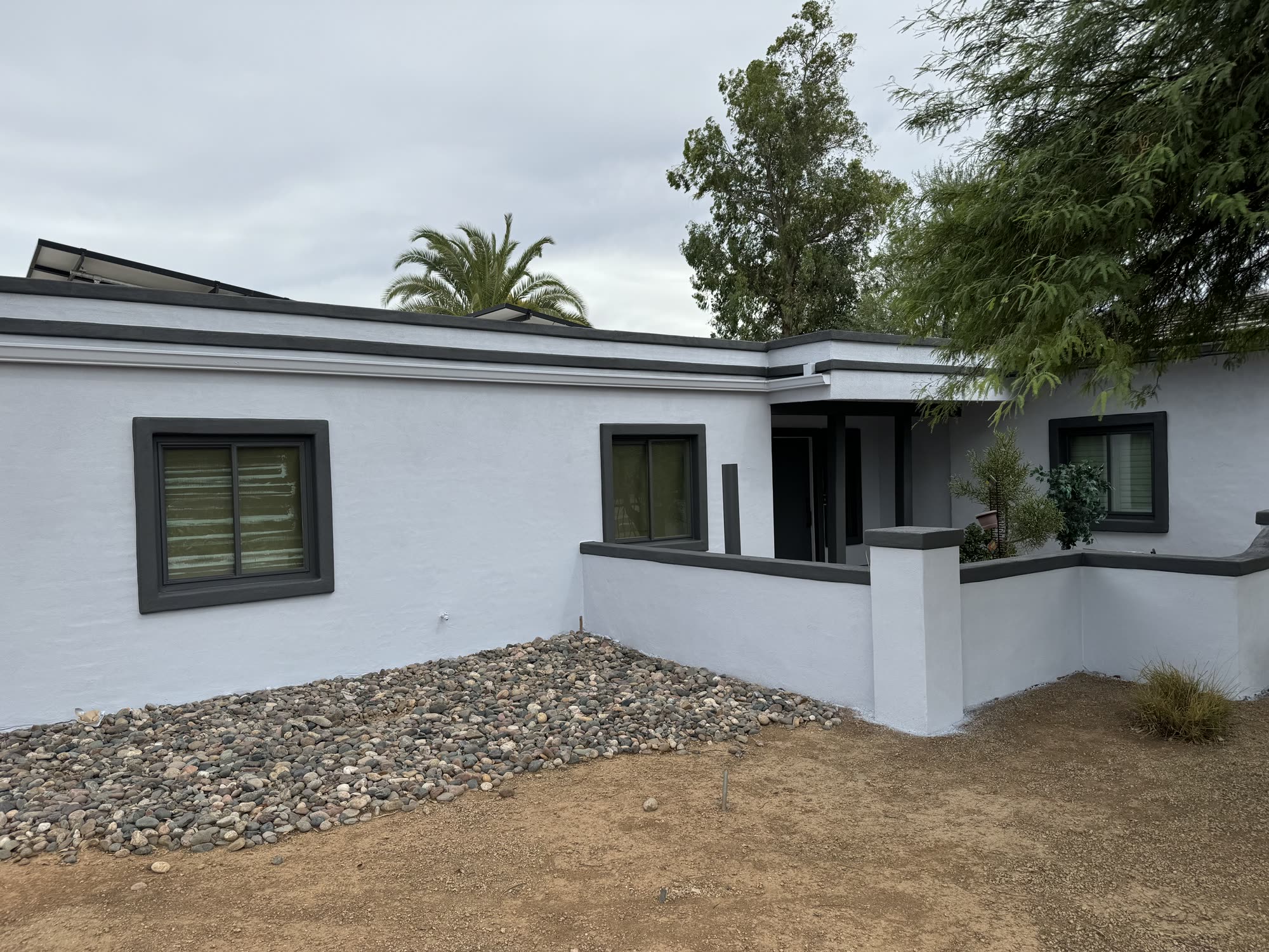 Modern white stucco Arizona home with crisp black trim and palm trees