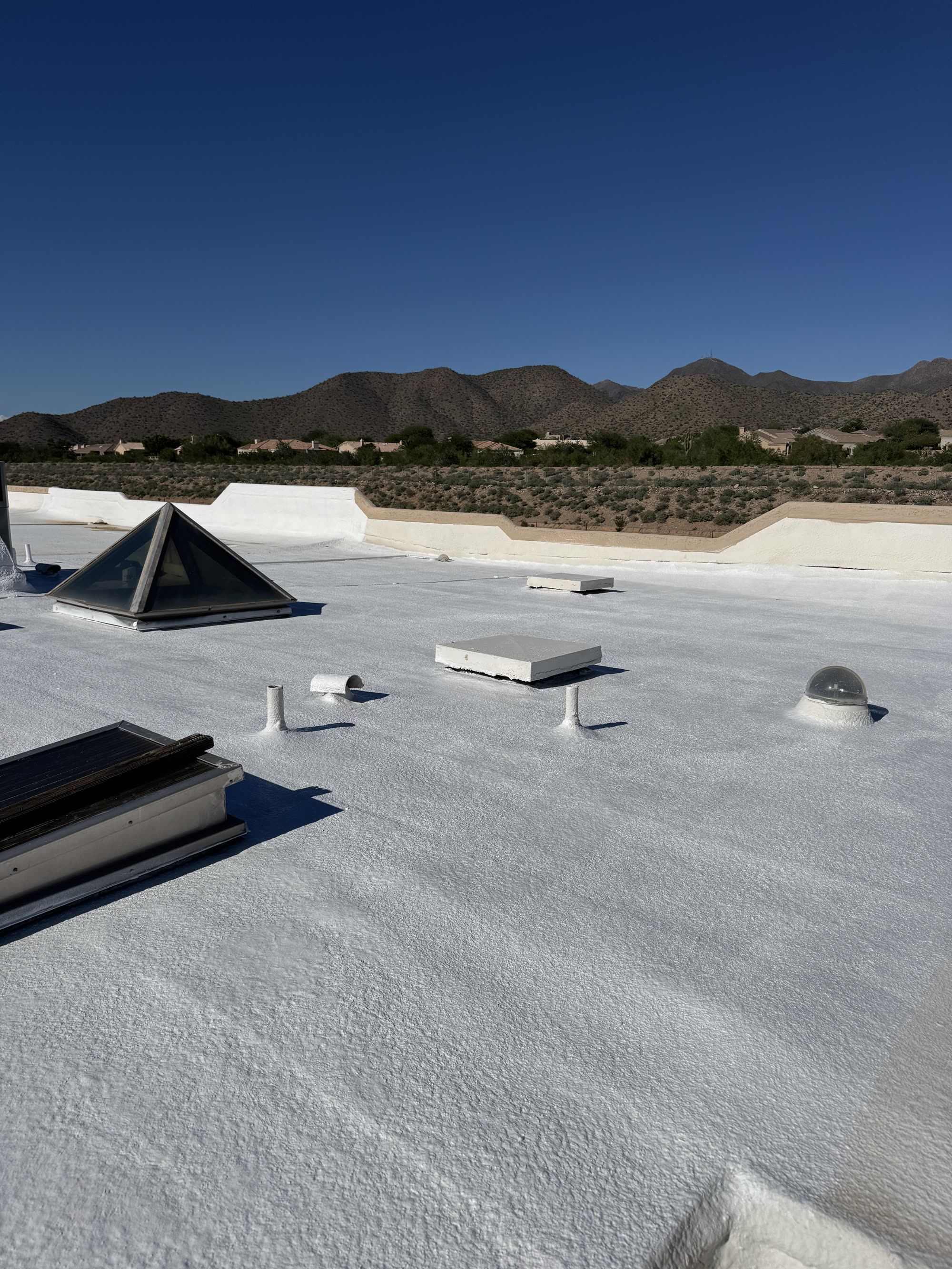 White reflective roof coating on a flat Arizona roof